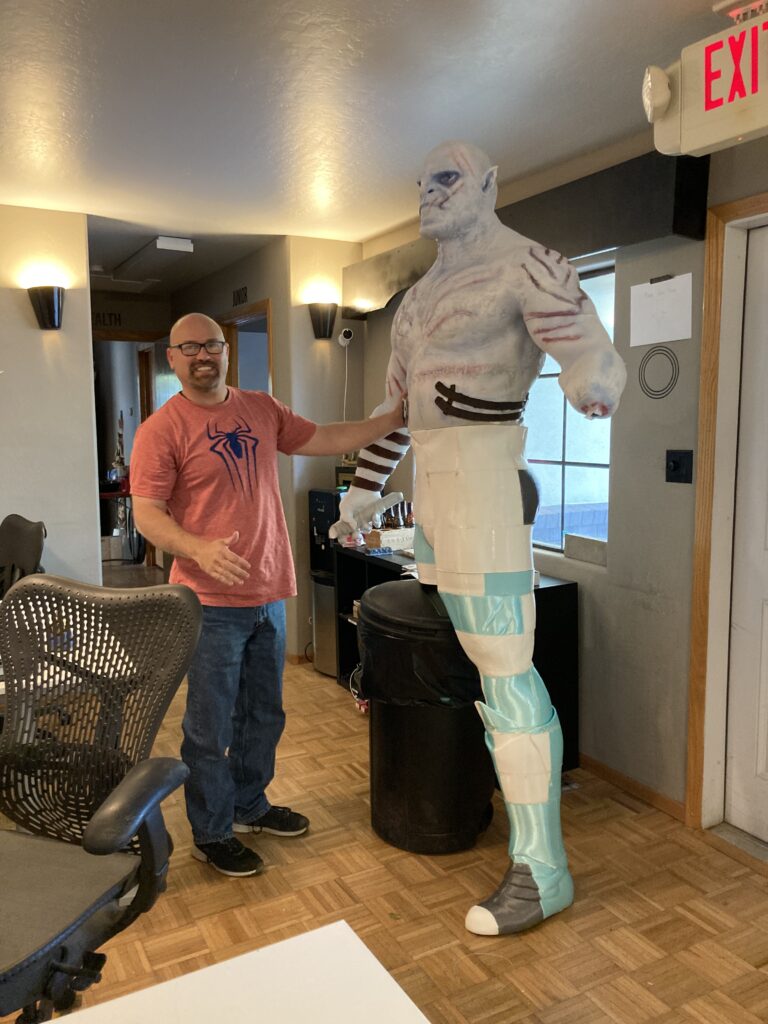 Azog statue being fitted with legs by a smiling Guy Parrulli